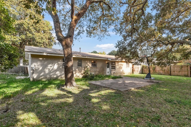 rear view of house featuring a yard and a patio area