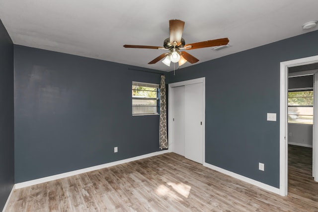 unfurnished bedroom featuring ceiling fan, light hardwood / wood-style flooring, and a closet