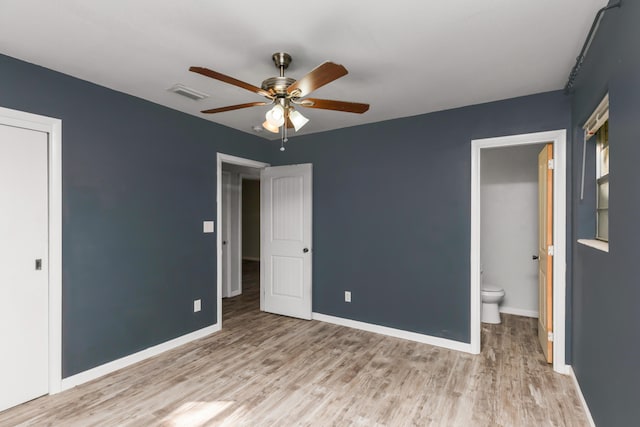 unfurnished bedroom featuring light hardwood / wood-style floors, ensuite bath, and ceiling fan