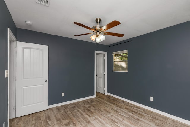 empty room with ceiling fan and hardwood / wood-style flooring