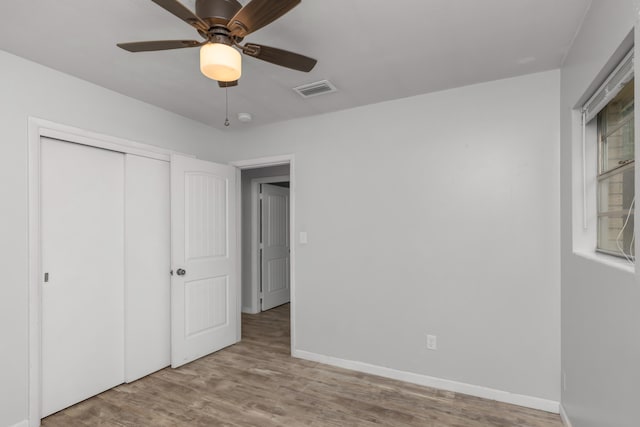 unfurnished bedroom with a closet, light hardwood / wood-style floors, and ceiling fan