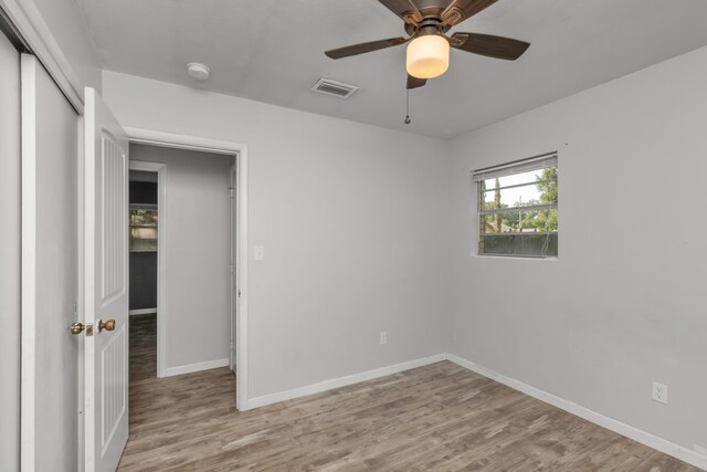 unfurnished bedroom featuring a closet, light hardwood / wood-style flooring, and ceiling fan