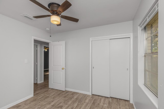 unfurnished bedroom featuring a closet, light hardwood / wood-style floors, and ceiling fan