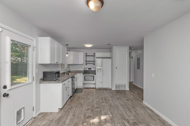 kitchen featuring stainless steel appliances, sink, light hardwood / wood-style flooring, and white cabinetry