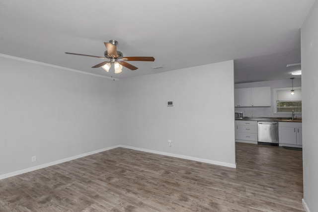 unfurnished room featuring crown molding, ceiling fan, dark wood-type flooring, and sink