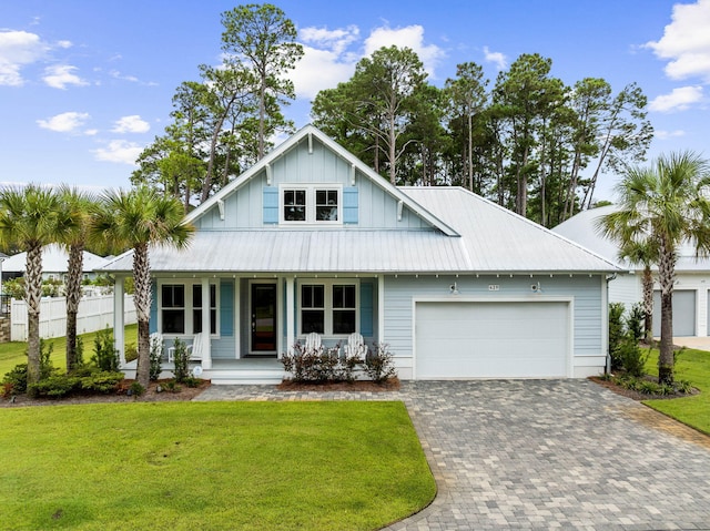 view of front of home featuring a garage, a porch, and a front lawn