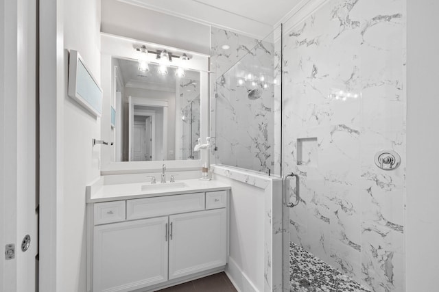 bathroom with a marble finish shower, vanity, and crown molding