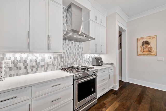 kitchen featuring dark wood-type flooring, wall chimney range hood, tasteful backsplash, stainless steel stove, and light countertops