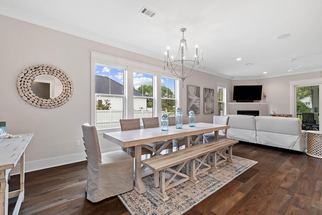 dining space featuring crown molding, dark wood-type flooring, and a notable chandelier