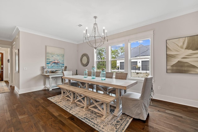 dining room featuring crown molding, dark hardwood / wood-style floors, and an inviting chandelier