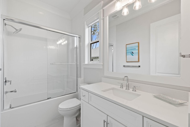 bathroom featuring combined bath / shower with glass door, toilet, and vanity