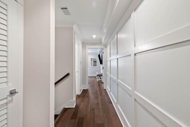 hall featuring visible vents, crown molding, baseboards, dark wood finished floors, and an upstairs landing