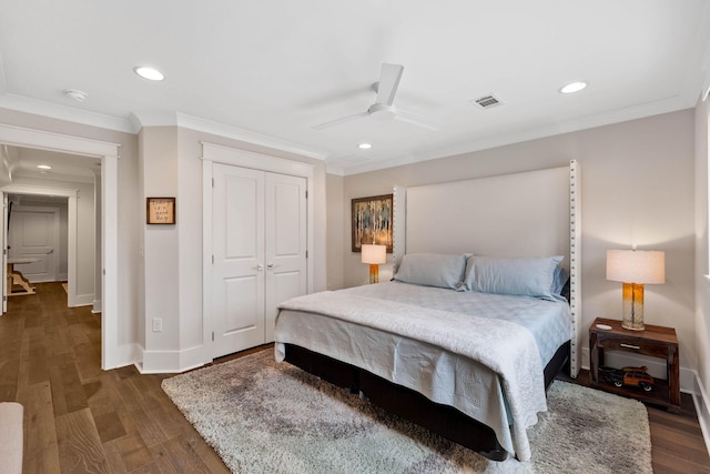 bedroom with ornamental molding, dark wood-type flooring, ceiling fan, and a closet