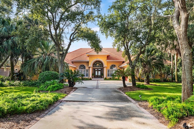 mediterranean / spanish-style home featuring french doors and a front lawn