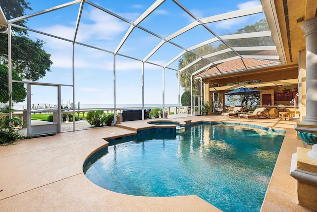 view of swimming pool featuring a patio, glass enclosure, and an in ground hot tub