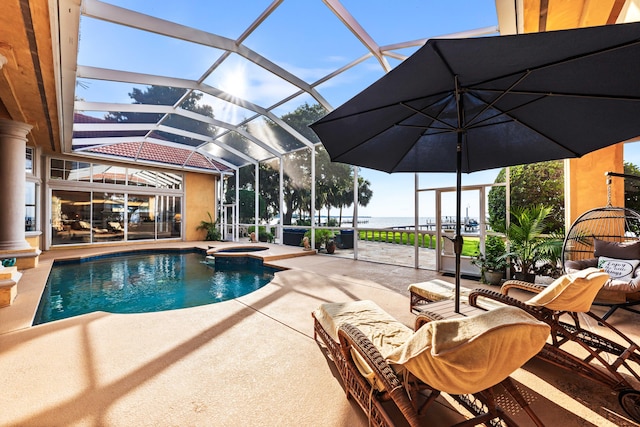 view of swimming pool with a lanai, a patio, a water view, and an in ground hot tub