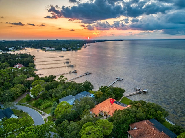 aerial view at dusk featuring a water view