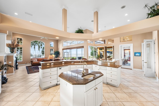 kitchen featuring dishwasher, a large island with sink, plenty of natural light, and a high ceiling