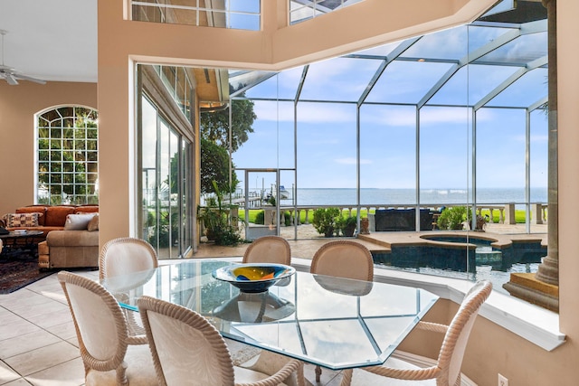 view of patio / terrace with glass enclosure, a water view, and a swimming pool with hot tub