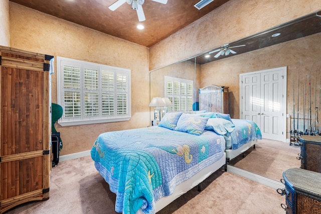 carpeted bedroom featuring a closet and ceiling fan