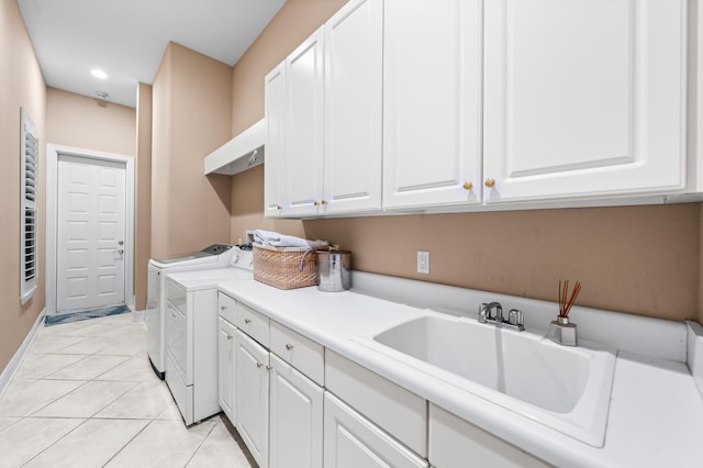 laundry room with washing machine and dryer, light tile patterned flooring, sink, and cabinets