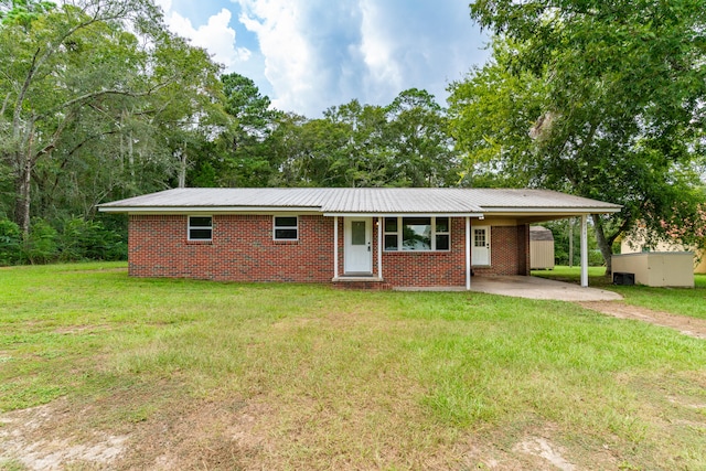 ranch-style house featuring a front lawn and a carport