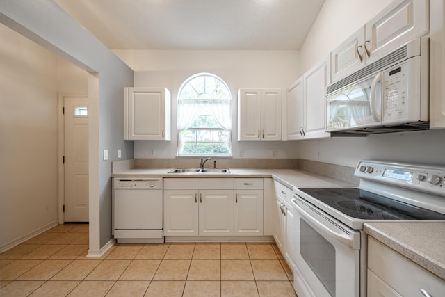 kitchen with white cabinets, white appliances, sink, and light tile patterned floors