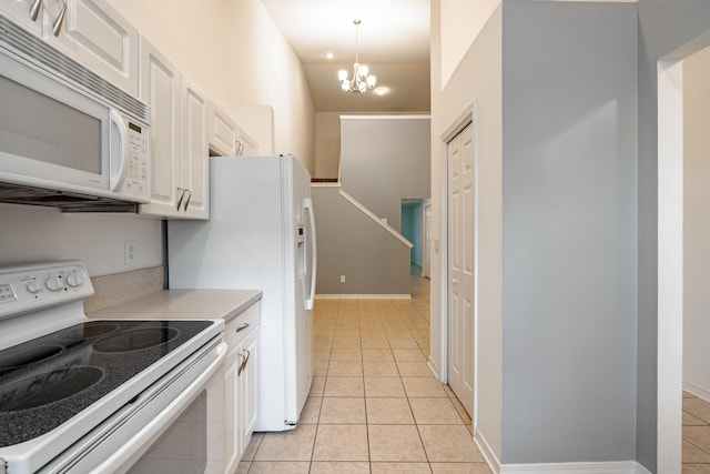 kitchen with white appliances, decorative light fixtures, an inviting chandelier, white cabinets, and lofted ceiling