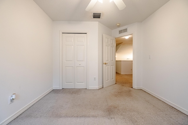 unfurnished bedroom with ceiling fan and a closet