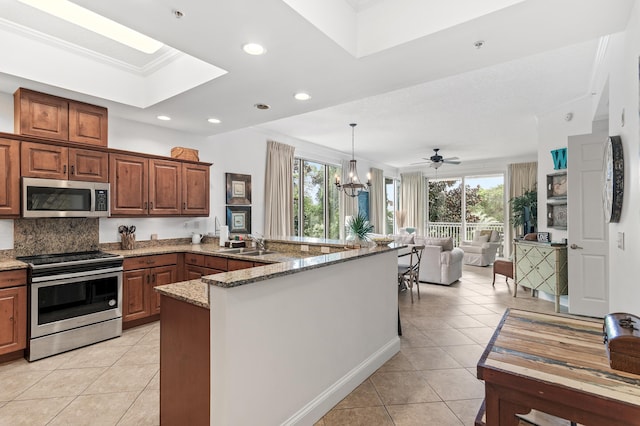 kitchen featuring crown molding, appliances with stainless steel finishes, a wealth of natural light, and decorative light fixtures