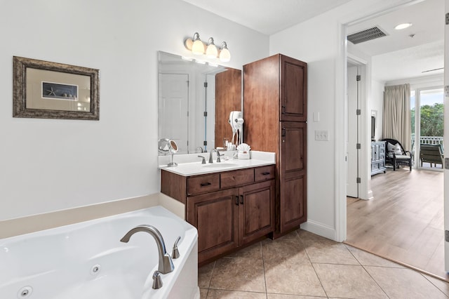 bathroom featuring a bath, tile patterned floors, and vanity