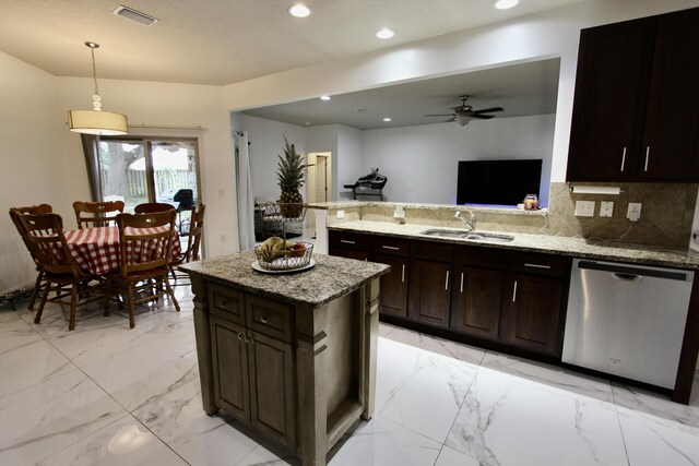 kitchen with light stone counters, sink, ceiling fan, hanging light fixtures, and stainless steel dishwasher