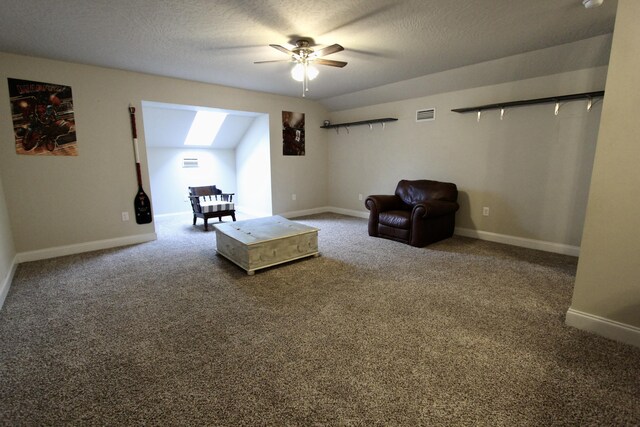 unfurnished room featuring a textured ceiling, lofted ceiling, ceiling fan, and carpet