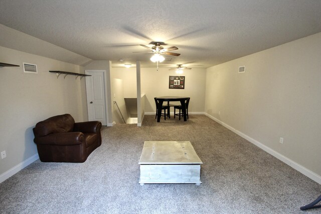 carpeted living room with a textured ceiling and ceiling fan