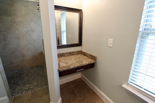 bathroom featuring a wealth of natural light, a tile shower, and tile patterned floors