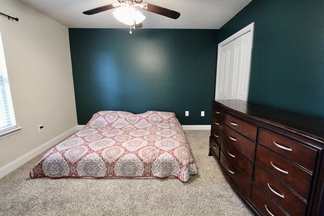 carpeted bedroom featuring ceiling fan and a closet