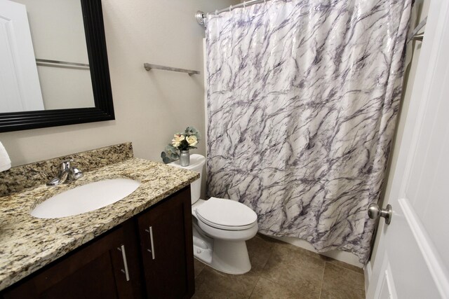 bathroom with a shower with shower curtain, vanity, toilet, and tile patterned floors