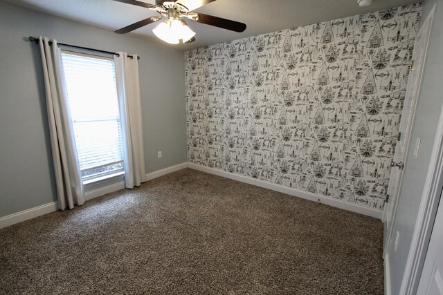 carpeted spare room with a healthy amount of sunlight and ceiling fan