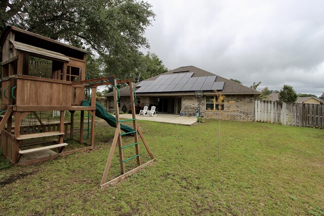 view of playground featuring a yard and a patio