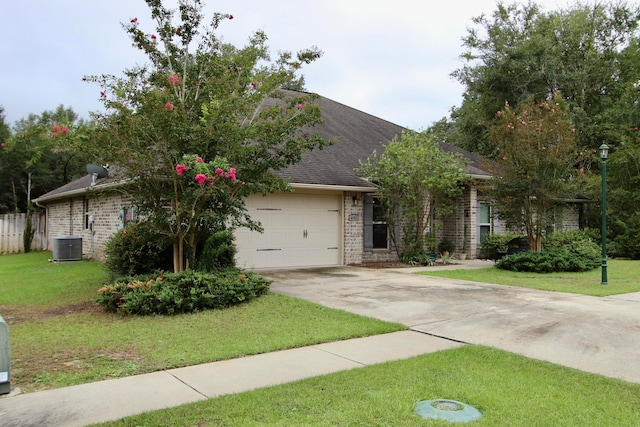 view of front of home featuring cooling unit, a garage, and a front yard