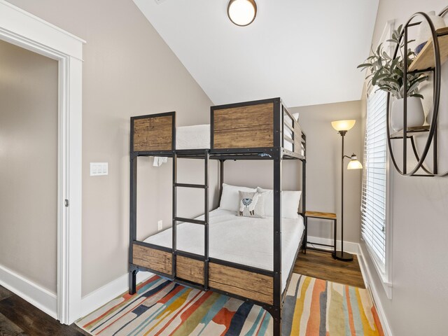 bedroom with lofted ceiling and dark hardwood / wood-style floors