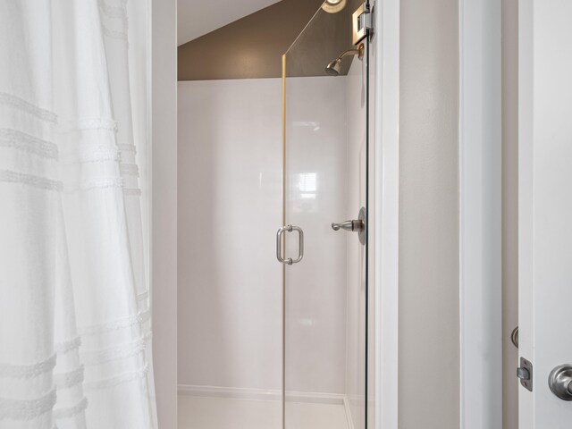 bathroom featuring vaulted ceiling and curtained shower