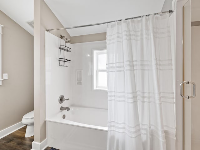 bathroom featuring shower / bath combo with shower curtain, toilet, and hardwood / wood-style floors