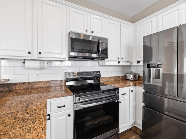 kitchen with dark wood-type flooring, white cabinetry, stainless steel appliances, and tasteful backsplash