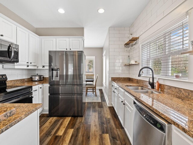 kitchen featuring dark wood-type flooring, appliances with stainless steel finishes, a wealth of natural light, and white cabinetry