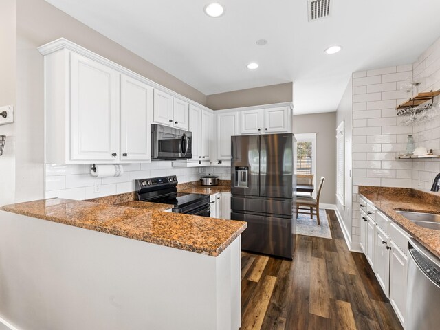 kitchen with stainless steel appliances, dark hardwood / wood-style flooring, white cabinetry, sink, and kitchen peninsula