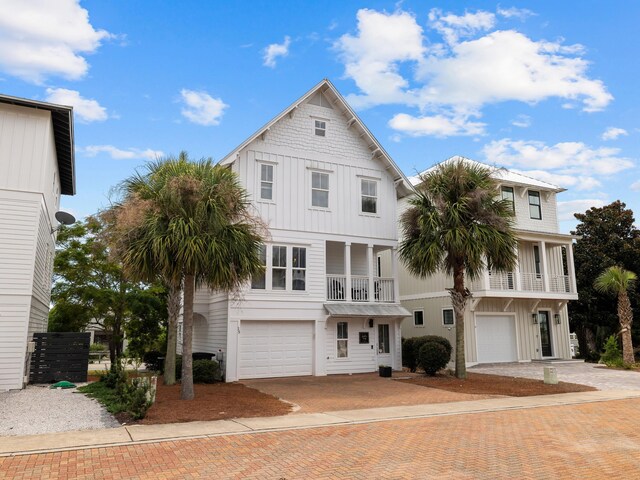 coastal inspired home with a garage and a balcony