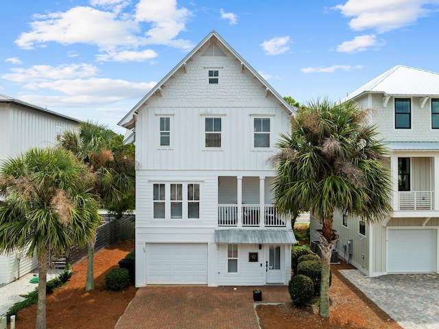 coastal inspired home featuring a balcony and a garage