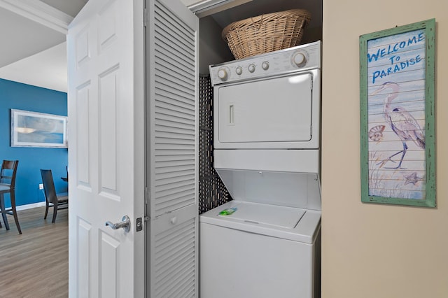 laundry room featuring light wood-type flooring and stacked washer and dryer