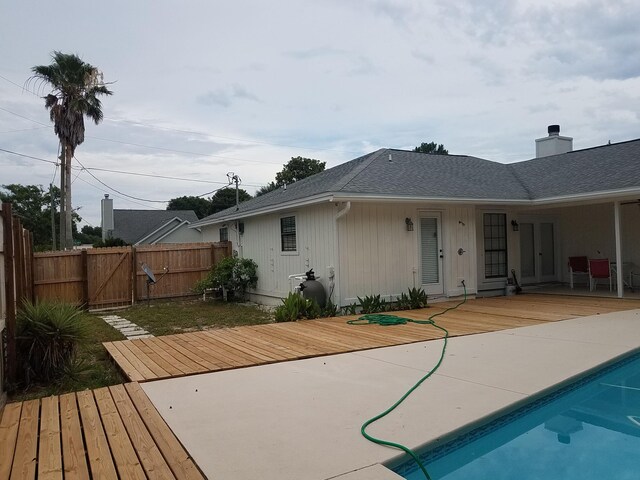 rear view of house with a pool side deck